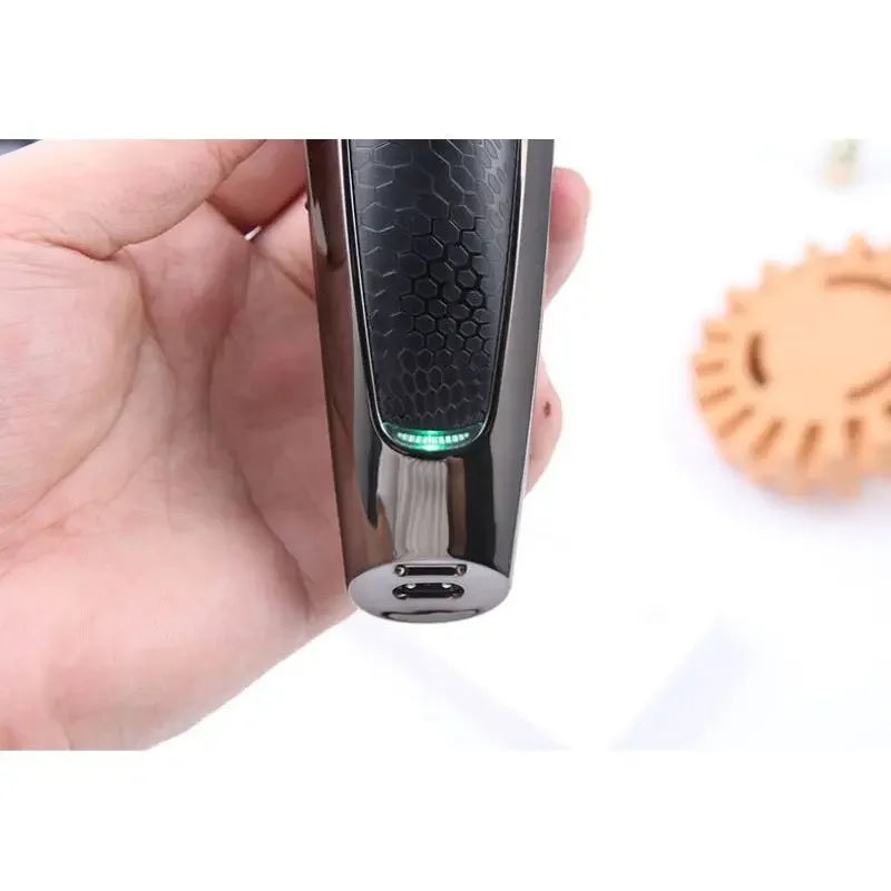 Hand holding black electric hair trimmer with hexagon grip and charging port